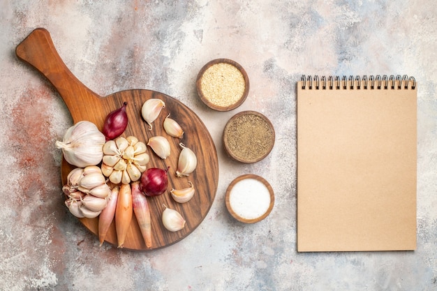 Kostenloses Foto draufsicht zwiebeln und knoblauch frische zutaten mit gewürzen