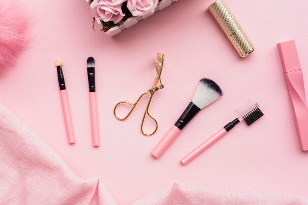 Draufsichtanordnung mit Make-upbürsten auf rosa Hintergrund