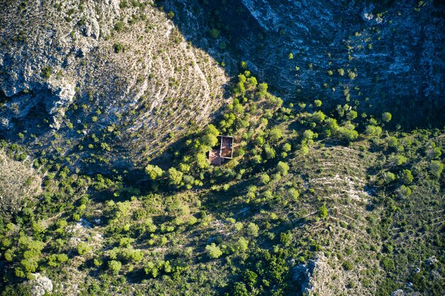 Draufsichtaufnahme eines verlassenen Hauses, umgeben von Grün