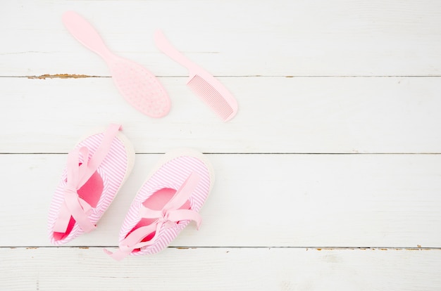 Draufsichtbabyschuhe mit hölzernem Hintergrund