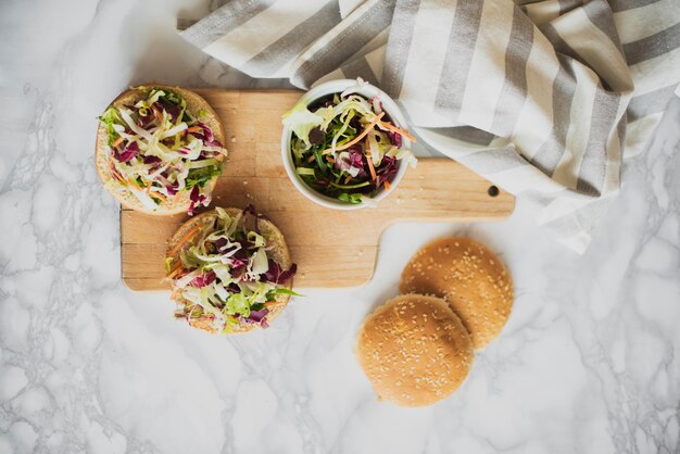 Draufsichtbrötchen mit frischem Salat auf Tabelle