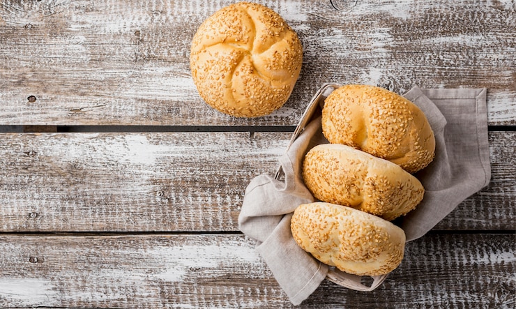 Kostenlose Foto draufsichtbrötchen mit indischem sesam auf hölzernem hintergrund