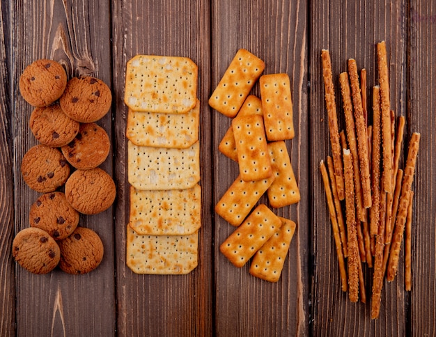 Draufsichtcracker mit Keksen und Grissini auf einem Holztisch