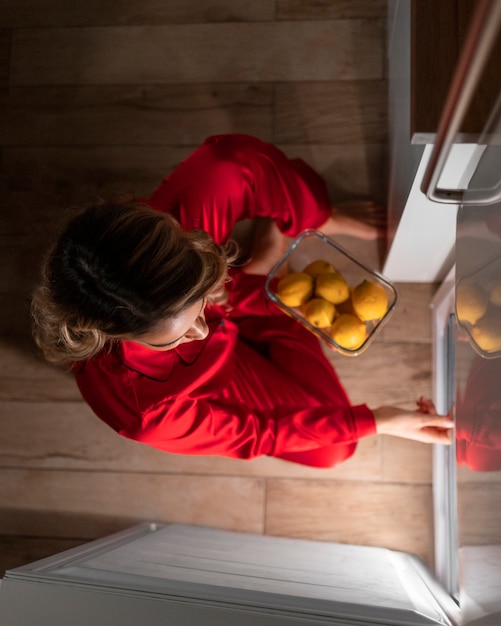 Kostenloses Foto draufsichtfrau mit essen nachts