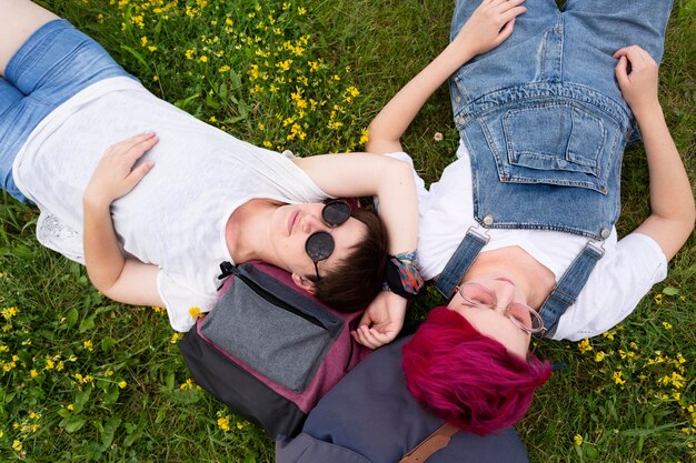 Kostenloses Foto draufsichtfreunde, die auf gras liegen