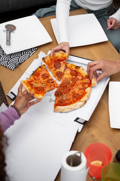 Kostenloses Foto draufsichtfreunde, die köstliche pizza essen