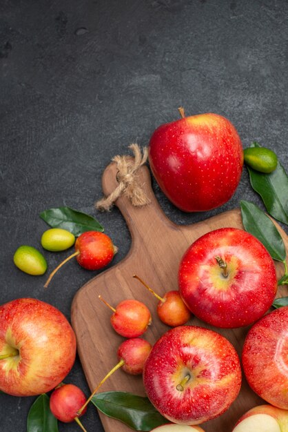 Draufsichtfrüchte Zitrusfrüchte neben den Äpfeln gelb-rote Beeren auf dem Brett