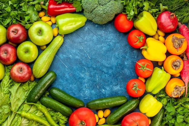 Draufsichtgemüsezusammensetzung mit frischen früchten auf der blauen tischfarbe reifen diätsalat gesunde lebensmahlzeit