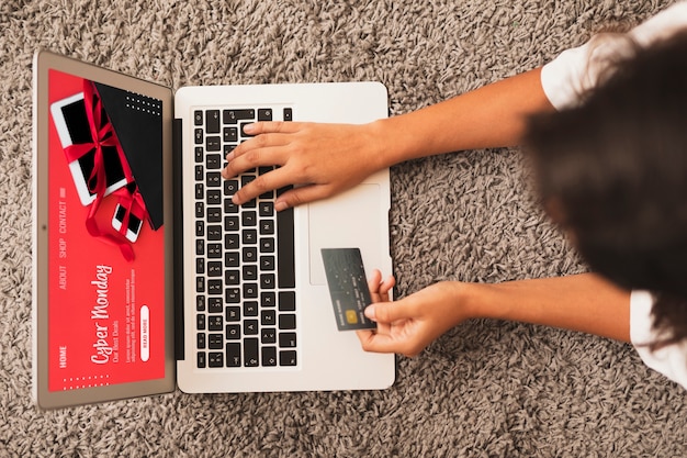 Kostenloses Foto draufsichthände, die auf laptop schreiben und einen kreditkartespott hochhalten