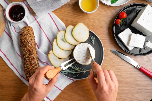 Kostenloses Foto draufsichthände, die käse schneiden