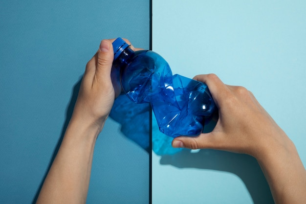 Draufsichthände, die plastikflasche halten