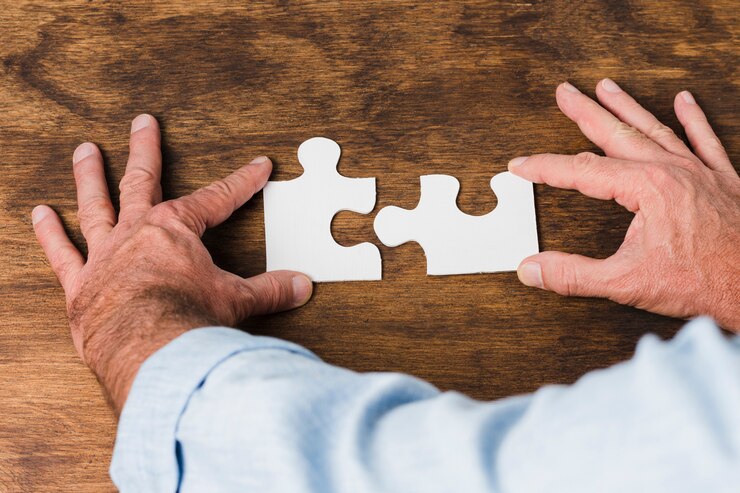Kostenlose Foto draufsichthände, die puzzlespiel auf holztisch machen