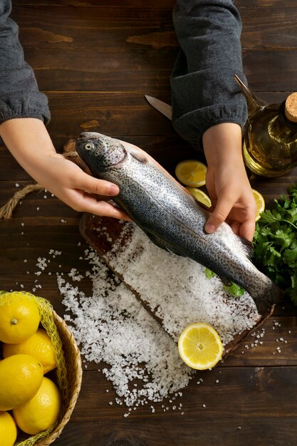 Draufsichthände, die rohe forelle kochen
