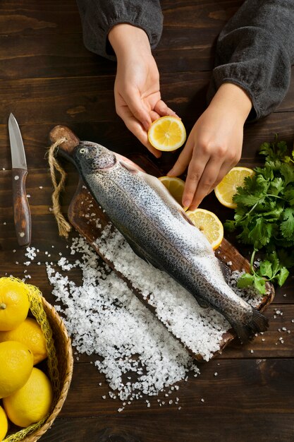 Draufsichthände, die rohe forelle kochen