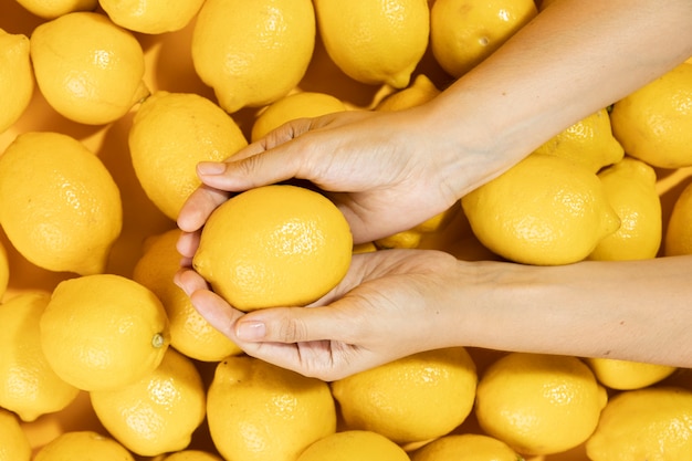 Draufsichthände, die rohe Zitrone halten