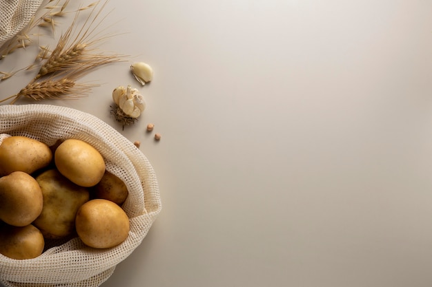 Draufsichtkartoffeln und -knoblauch mit Kopienraum