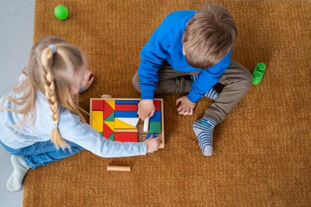 Draufsichtkinder, die zusammen mit spielzeug spielen