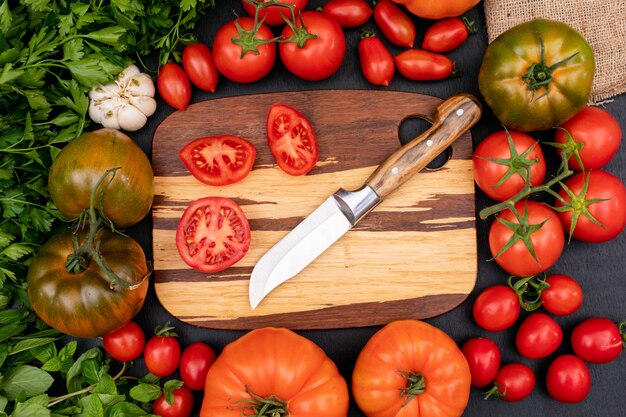 Draufsichtkonzept der Tomaten mit Messer auf Schneidebrett