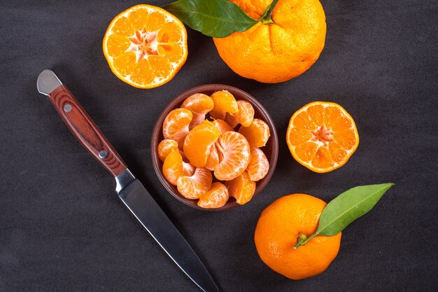 Kostenloses Foto draufsichtmandarine in der platte mit messer