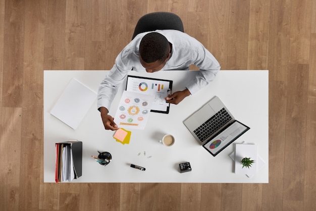 Kostenloses Foto draufsichtmann, der am schreibtisch arbeitet