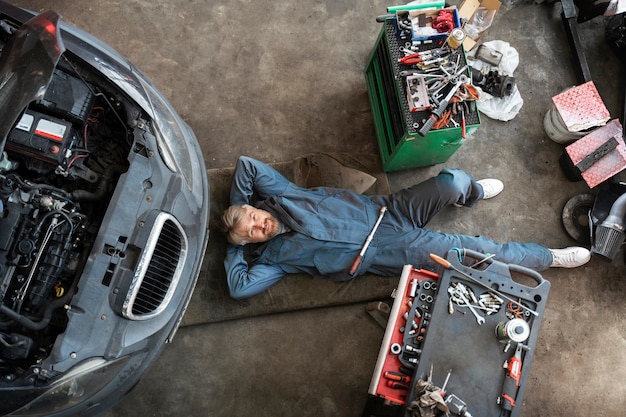 Kostenloses Foto draufsichtmann, der auto repariert