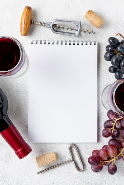 Draufsichtnotizbuch mit Rahmen von Trauben und von Wein