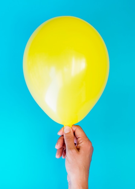 Kostenloses Foto draufsichtperson, die gelben ballon hält