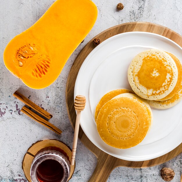 Draufsichtpfannkuchen auf Platte mit Moschuskürbishälfte