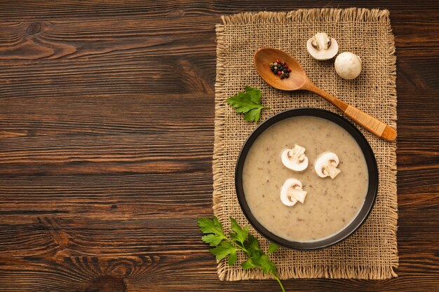 Draufsichtpilzbiskuitcremesuppe und -löffel mit Kopienraum