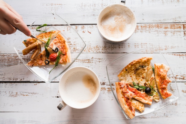 Draufsichtpizza und -kaffee auf weißer Tabelle