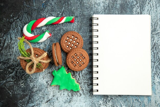 Draufsichtplätzchen gebunden mit Seilenplätzchen Weihnachtsbonbons Notizblock auf grauer Oberfläche