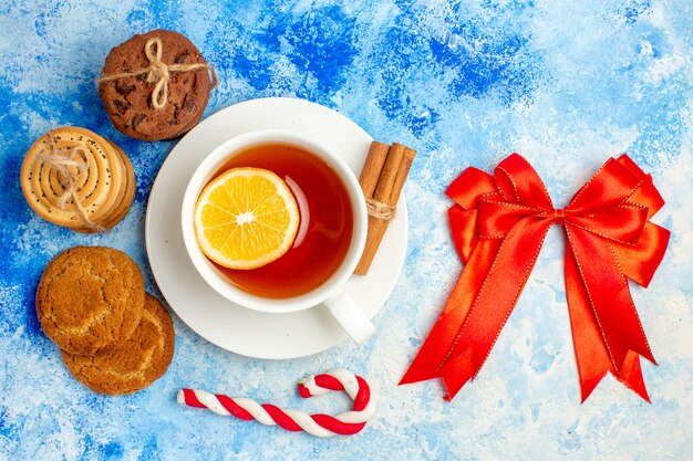 Draufsichtplätzchen gefesselt mit rotem Seiltasse Tee auf blauem Tisch