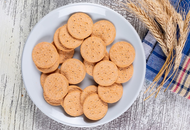 Kostenloses Foto draufsichtplätzchen mit weizen auf stoff auf weißer hölzerner horizontaler