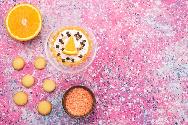 Draufsichtplätzchen und Kuchen mit der orange Hälfte auf der hellen Oberfläche Kekskeksfruchtkuchenzuckersüß