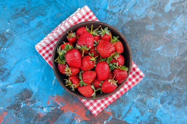 Draufsichtplatte mit frischen leckeren reifen früchten der erdbeeren auf blauem hintergrund