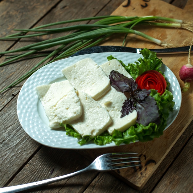 Draufsichtplatte mit Käse mit Frühlingszwiebeln und Basilikum