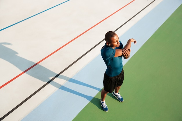 Draufsichtporträt eines jungen afrikanischen Sportlers, der sich ausdehnt