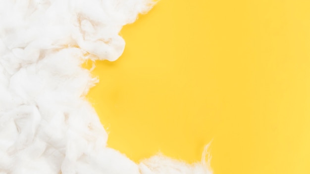 Kostenloses Foto draufsichtrahmen mit baumwolle auf gelbem hintergrund