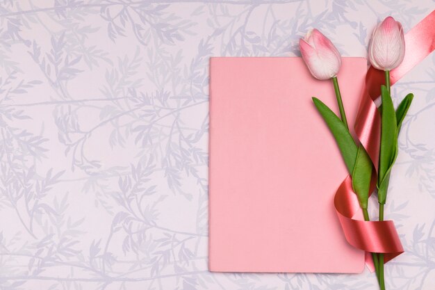 Draufsichtrahmen mit Tulpen und Notizbuch