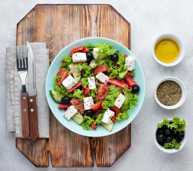 Draufsichtsalat mit Feta-Käse auf Schneidebrett mit Oliven