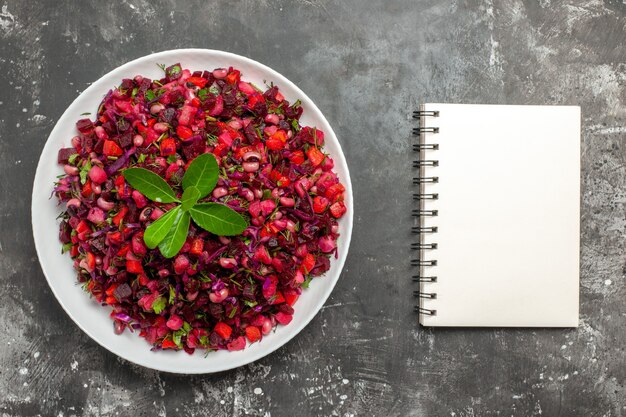 Draufsichtsalat mit rotem Gemüse in einer weißen Schale auf grauem Hintergrund