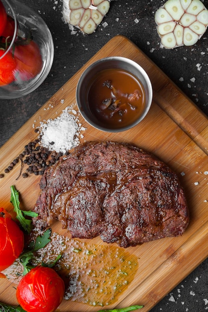 Draufsichtsteak mit Tomate und würziger Soße im Steakbrett