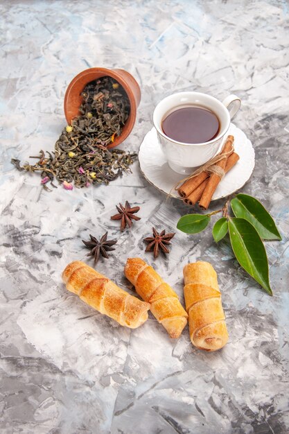 Draufsichttasse tee mit bagels auf weißem tischteekuchenteig