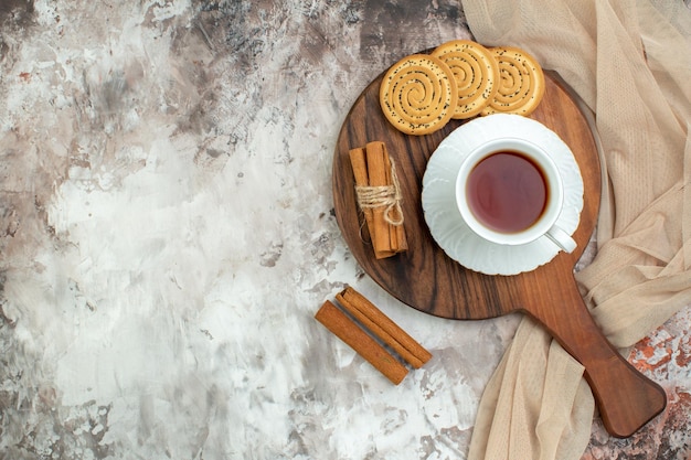 Draufsichttasse tee mit süßen keksen auf dem hellen hintergrund farbe zeremonie kuchen zuckerpause plätzchen kaffee Premium Fotos