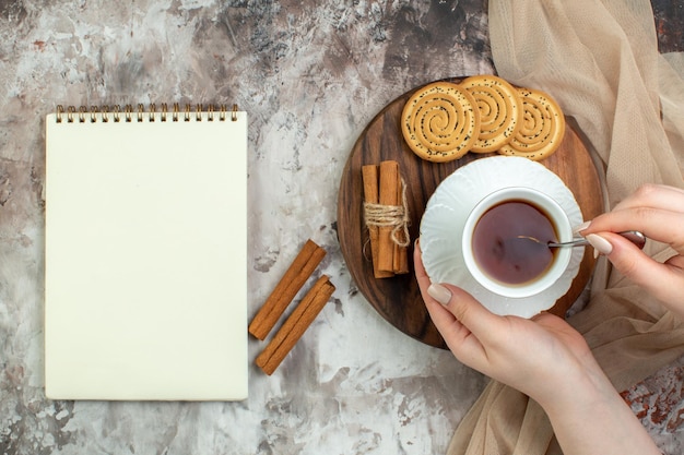 Draufsichttasse Tee mit süßen Keksen auf einem hellen Hintergrundfarbzeremonie-Kuchen-Kaffee-Zuckerpause-Cookie