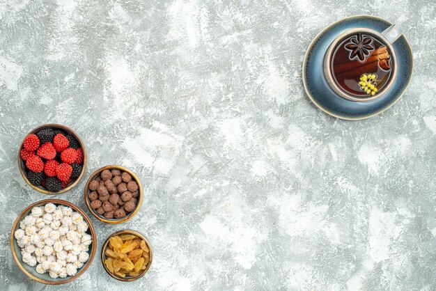 Draufsichttasse tee mit verschiedenen bonbons auf weißem raum