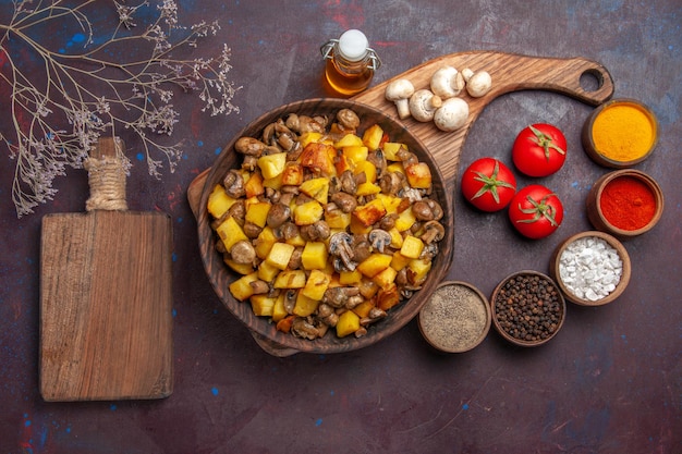 Draufsichtteller mit Speiseteller mit Pilzen und Kartoffeln Öl in der Flasche Tomaten Pilze bunte Gewürze und Schneidebrett