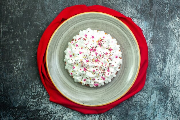 Draufsichttorte mit cremerotem Schal auf grauem Hintergrund