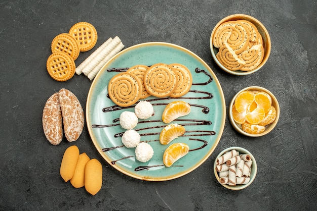 Draufsichtzuckerplätzchen mit Bonbons und Keksen auf grauem Hintergrund