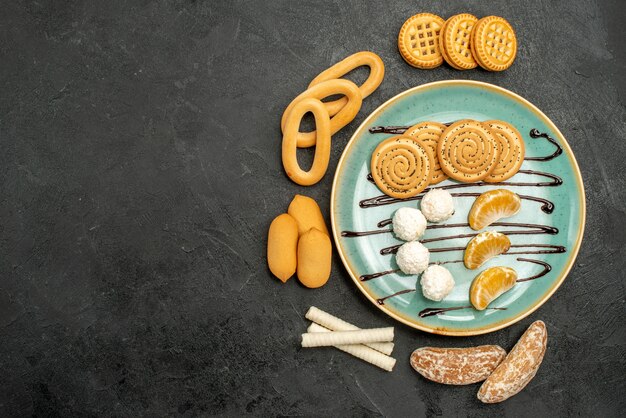 Draufsichtzuckerplätzchen mit Keksen und Bonbons auf dem grauen Hintergrund